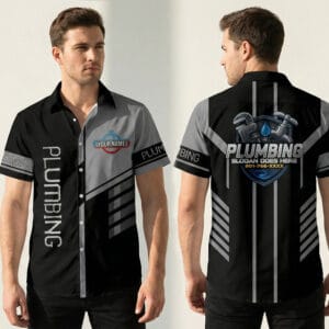 Front view of a black and grey color block plumber shirt featuring custom name logo on chest and vertical plumbing text.