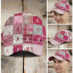 Front view of the pink ribbon patchwork cap on wood, featuring frayed squares in pink, grey, and white plaid and floral.