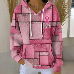 Personalized breast cancer hoodie in pink with patchwork design, featuring a name and ribbon, front view.