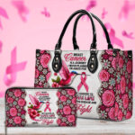 Front view of white and pink floral breast cancer journey handbag featuring a hummingbird, pink ribbon, and black handles.