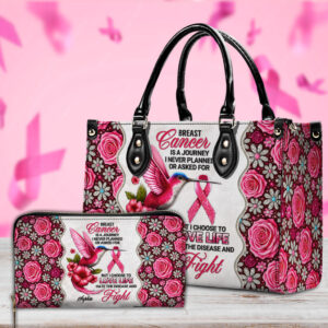 Front view of white and pink floral breast cancer journey handbag featuring a hummingbird, pink ribbon, and black handles.