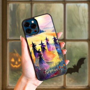 Lifestyle view of a hand holding a custom watercolor witch phone case featuring purple sunset colors and coven design.