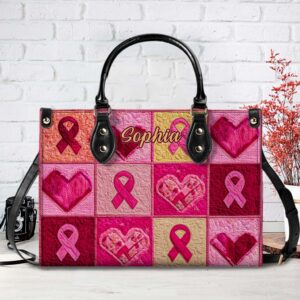 Front view of a custom pink ribbon patchwork handbag in PU leather, featuring hearts, ribbons, and a personalized name.