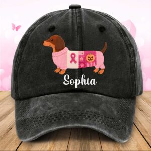 Front view of black denim dachshund breast cancer hat featuring customized name Sophia and dog in pink ribbon sweater.