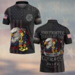 Front of dark fueled by fire polo with eagle holding an axe, fire dept badge, and faded US flag pattern.