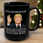 Front view of the you're a great daughter-in-law mug showcasing the design in black with humorous text and Trump image.