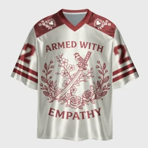Front view of the armed with empathy oversized jersey featuring a bold design in cream and maroon.