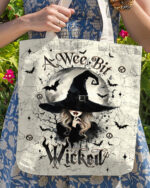 Front view of the wee bit wicked tote bag featuring a witch and bats on a cream background.