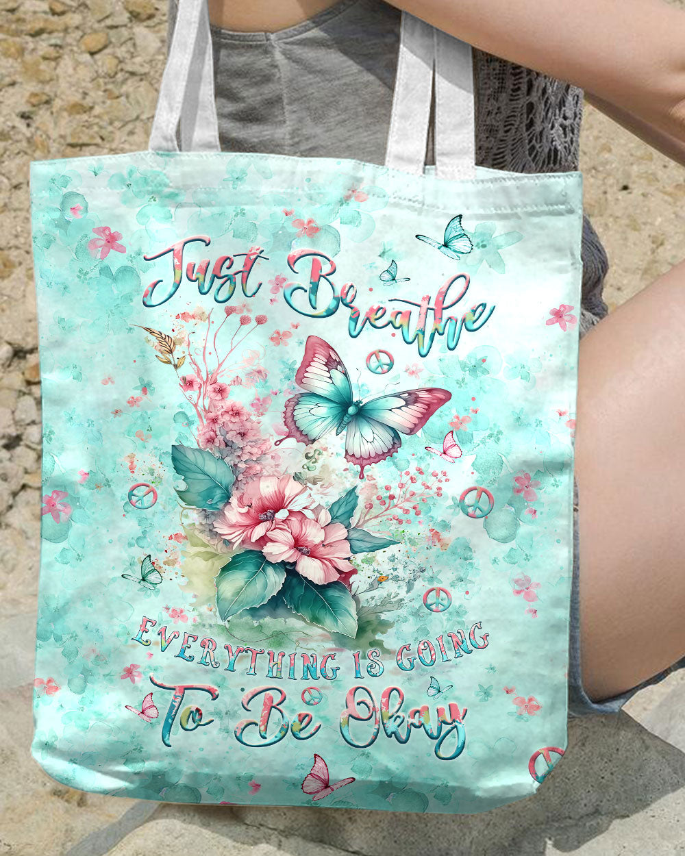 Just Breathe Butterfly Tote Bag Lifestyle shot of the just breathe butterfly tote bag being held, featuring a calming design with the phrase 'Just Breathe' p