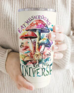 Front view of the Eat Mushrooms See the Universe tumbler showcasing vibrant mushroom designs in a cozy setting.