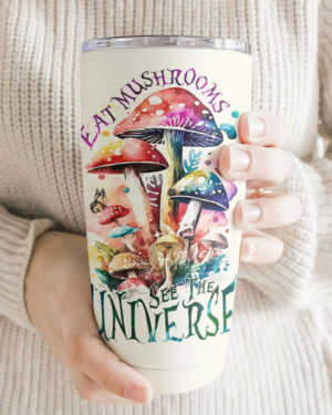 Front view of the Eat Mushrooms See the Universe tumbler showcasing vibrant mushroom designs in a cozy setting.