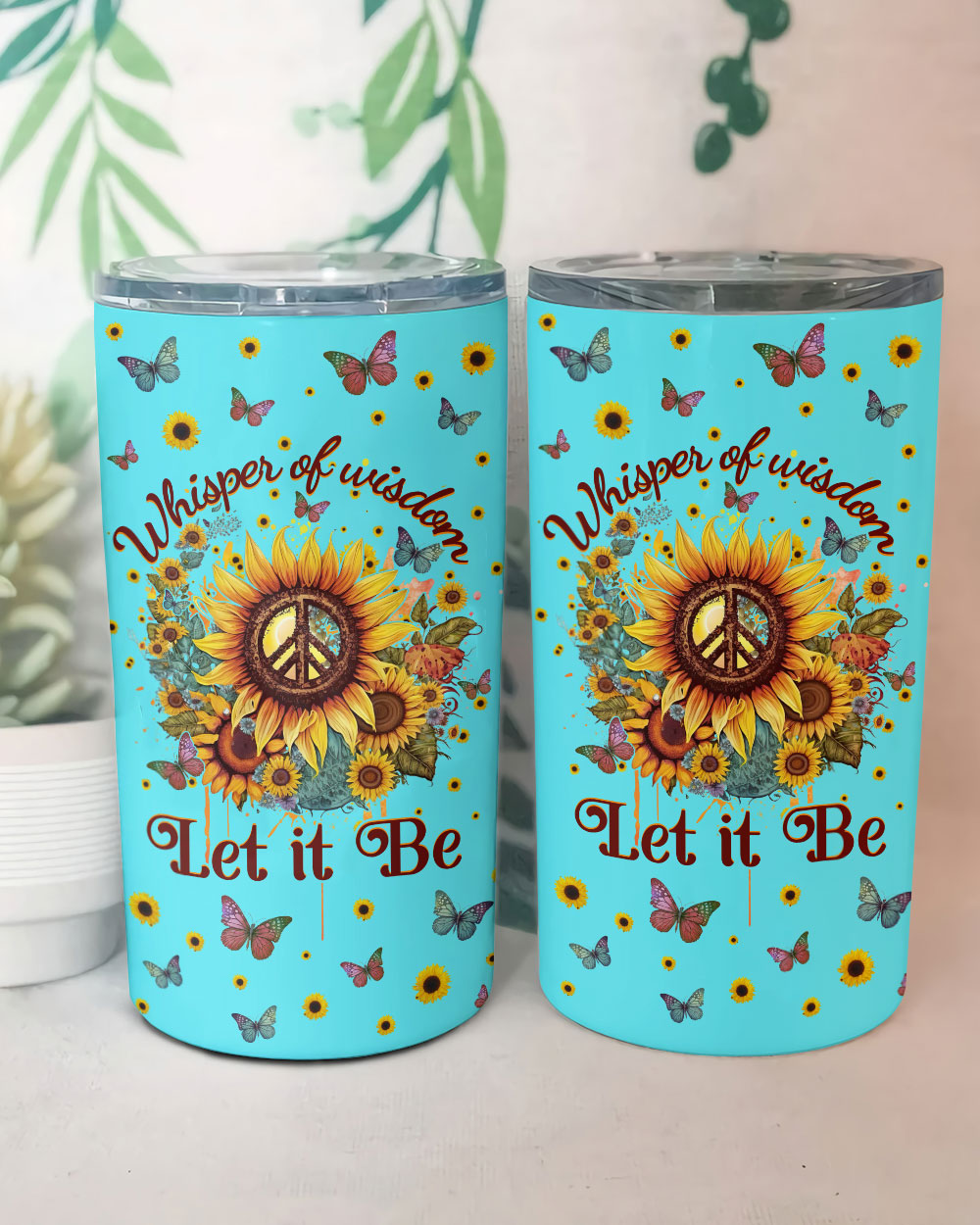 Whisper of Wisdom Sunflower Insulated Tumbler Front angle of the Whisper of Wisdom sunflower tumbler featuring 'Let it Be' text and butterflies against a blue background.