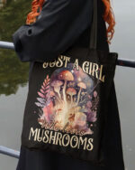 Front view of the black tote bag featuring 'Just a Girl Who Loves Mushrooms' with a colorful mushroom design.