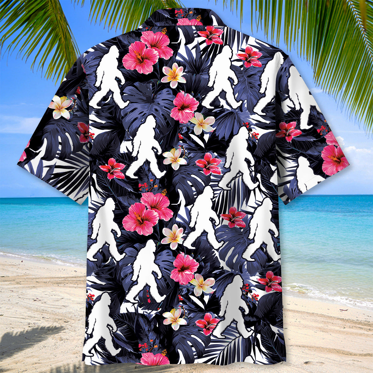 Tropical Bigfoot Walking Hawaiian Shirt Lifestyle shot of the tropical bigfoot walking Hawaiian shirt worn at the beach, with palm trees in the background.