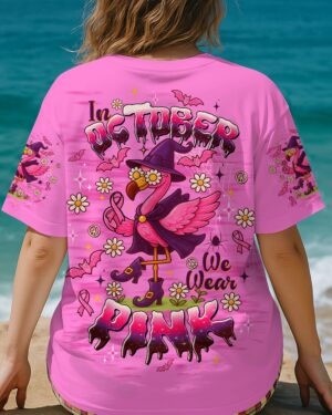Back view of pink shirt featuring 'In October We Wear Pink Flamingo' design with flowers and bats.