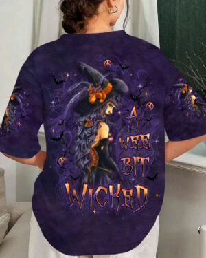 Front view of a wee bit wicked witch shirt in purple with striking witch design and Halloween motifs.