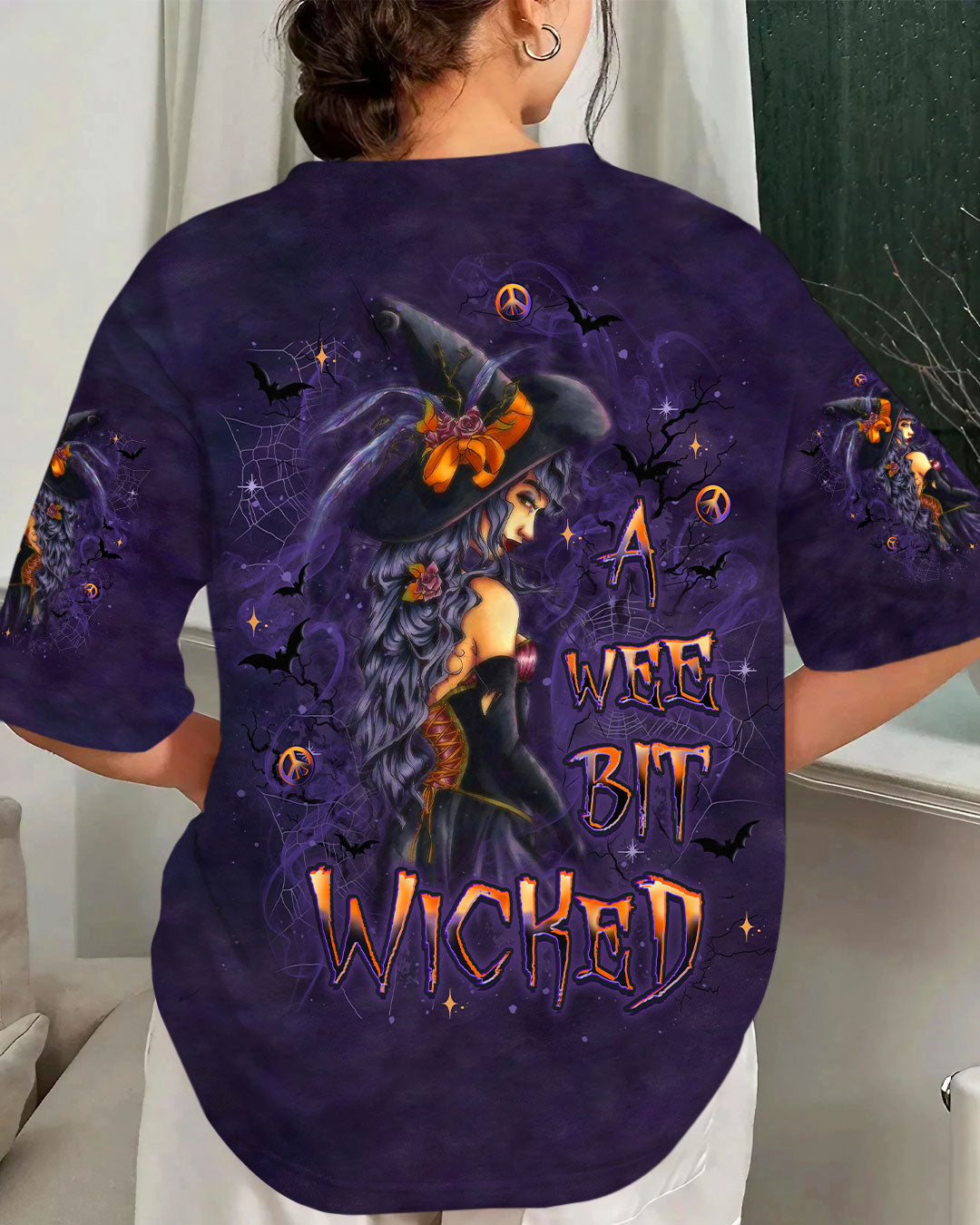 A Wee Bit Wicked Witch Shirt | All Over Print Front view of a wee bit wicked witch shirt in purple with striking witch design and Halloween motifs.