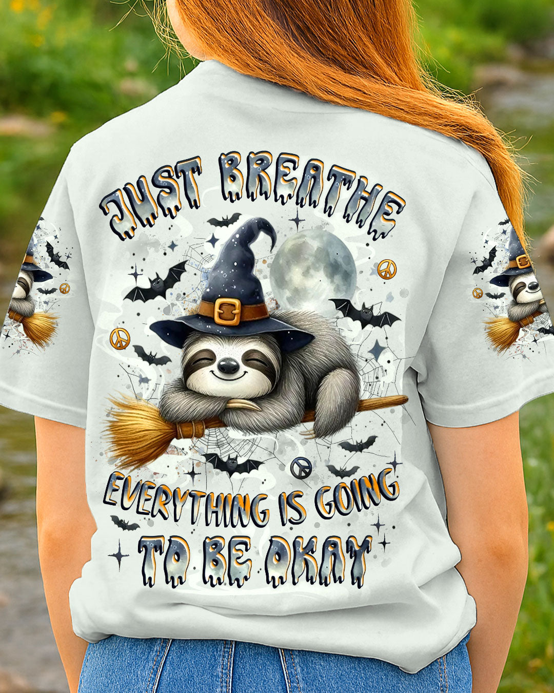 Just Breathe Sloth Witch Halloween Shirt Just breathe sloth witch shirt featuring a playful sloth design in grey, viewed from the back in a natural setting.