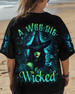 Front view of a black tee featuring 'A Wee Bit Wicked Halloween' with vivid witch design.