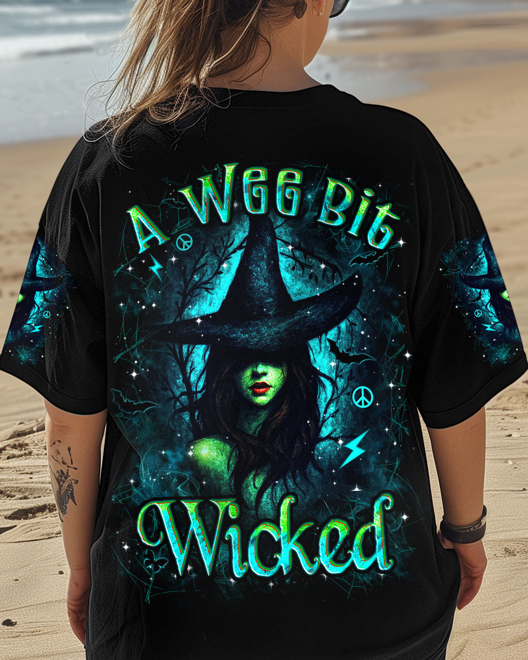 Front view of a black tee featuring 'A Wee Bit Wicked Halloween' with vivid witch design.