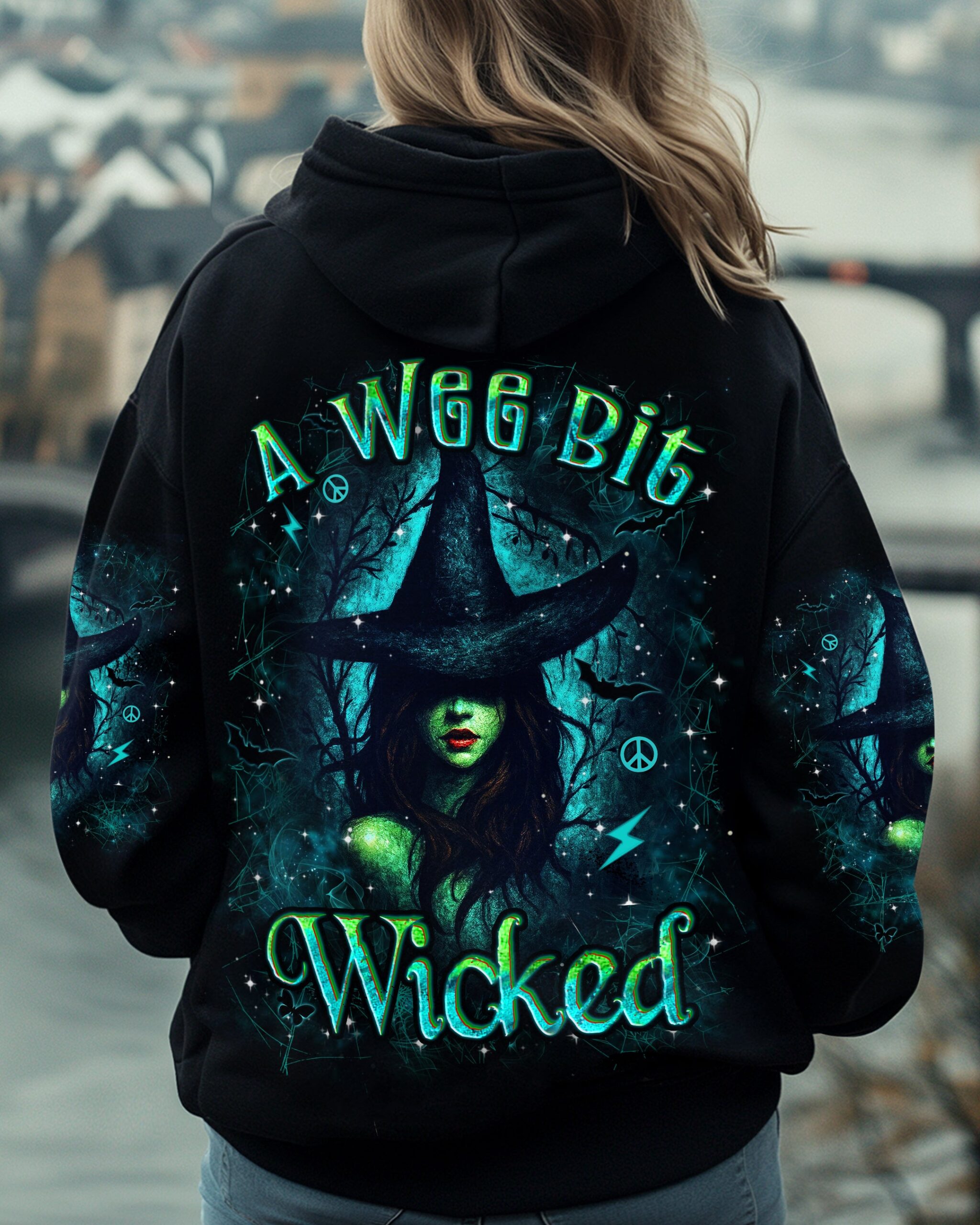 Model wearing 'A Wee Bit Wicked Halloween' shirt at a Halloween party, capturing the festive spirit.