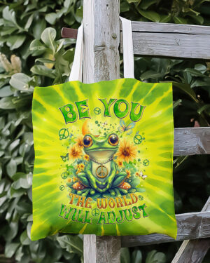 Front view of the be you the world will adjust frog tote bag featuring vibrant tie-dye colors and a cheerful frog design.