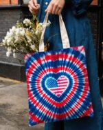 Front view of the american flag heart tote bag featuring a vibrant tie-dye design in red, white, and blue.