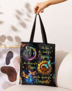 Front view of the spirit of a dragonfly tote bag featuring vibrant cosmic designs and a black background.