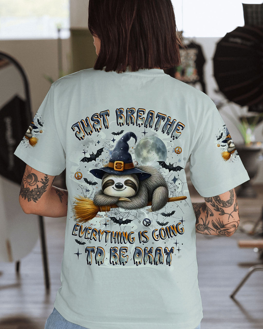 Just Breathe Sloth Witch Halloween Shirt Close-up detail of the just breathe sloth witch shirt's sloth and moon design, highlighting intricate artwork and textures.
