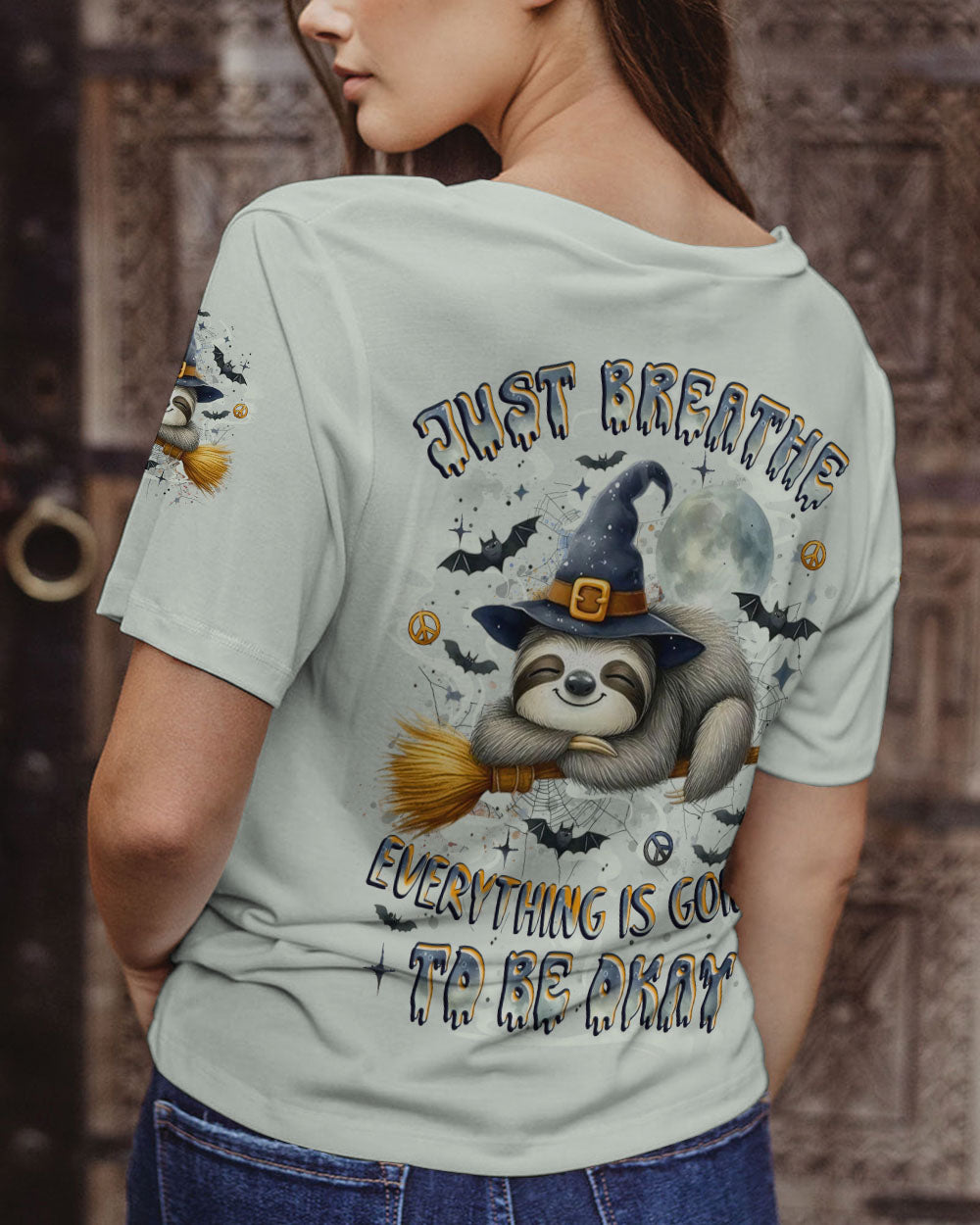 Just Breathe Sloth Witch Halloween Shirt Model wears the just breathe sloth witch shirt while walking in a park, capturing a relaxed autumn vibe.