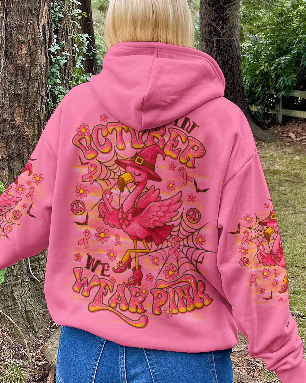 Pink Flamingo Witch Shirt | All Over Print Clothes Model wearing the pink flamingo witch shirt at a Halloween party, blending fun and awareness.