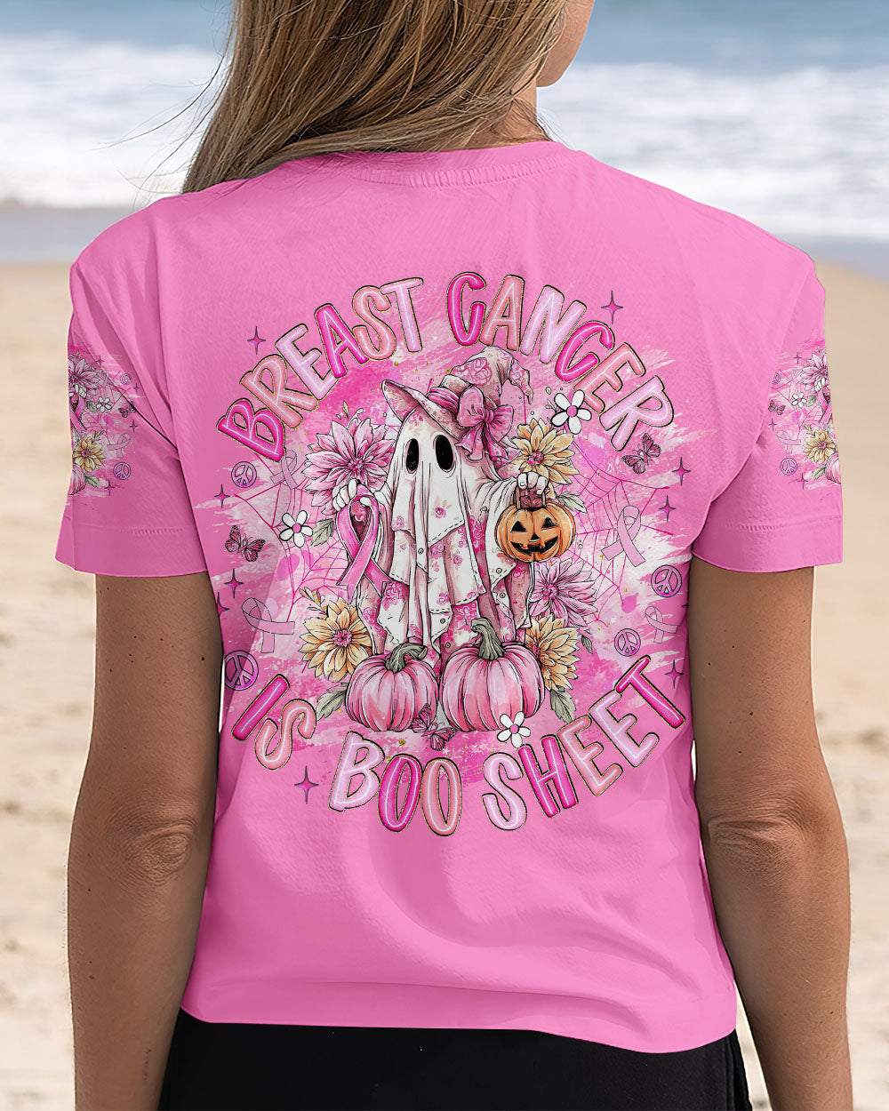 Breast Cancer Is Boo Sheet Shirt | All Over Print Lifestyle image featuring the breast cancer is boo sheet shirt worn outdoors, surrounded by autumn flowers.