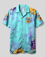 Front view of the just breathe dragonfly camp shirt in light blue with vibrant floral patterns.