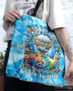 Front view of the old hippie don't die tote bag featuring vibrant tie-dye colors and floral design.