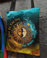 Front view of the live by the sun moon stars tote bag featuring vibrant colors and celestial design.