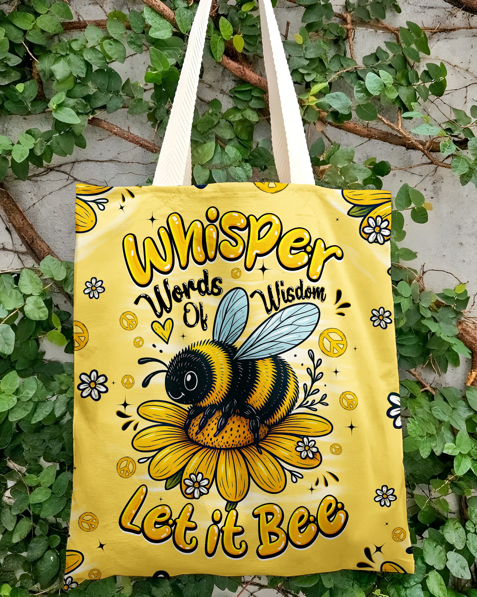 Let It Bee Tote Bag | Whimsical Floral Design Lifestyle shot of the Let It Bee tote bag being held, showcasing its cheerful yellow color and whimsical artwork.