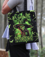 Front view of a wee bit wicked Halloween tote bag featuring a vibrant witch design and spooky green accents.