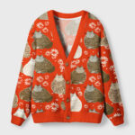 Front view of the fat cat cardigan sweater featuring a vibrant orange color and playful cat designs.