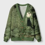 Front view of the cat under the moon cardigan sweater featuring a green color and celestial cat design.