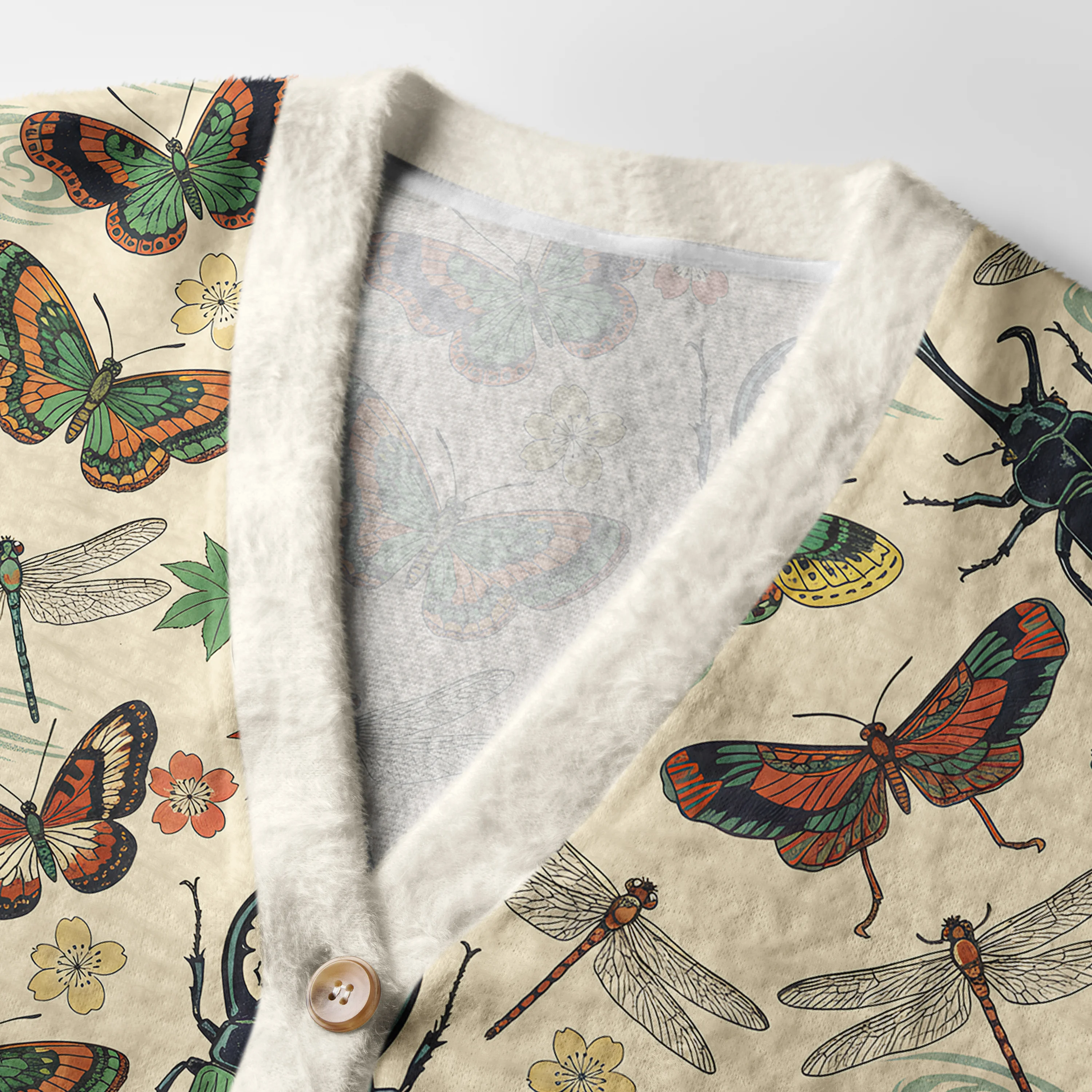 Insect World Cardigan Sweater Close-up detail of the insect world cardigan sweater's vibrant insect patterns and soft texture against a neutral backdrop.