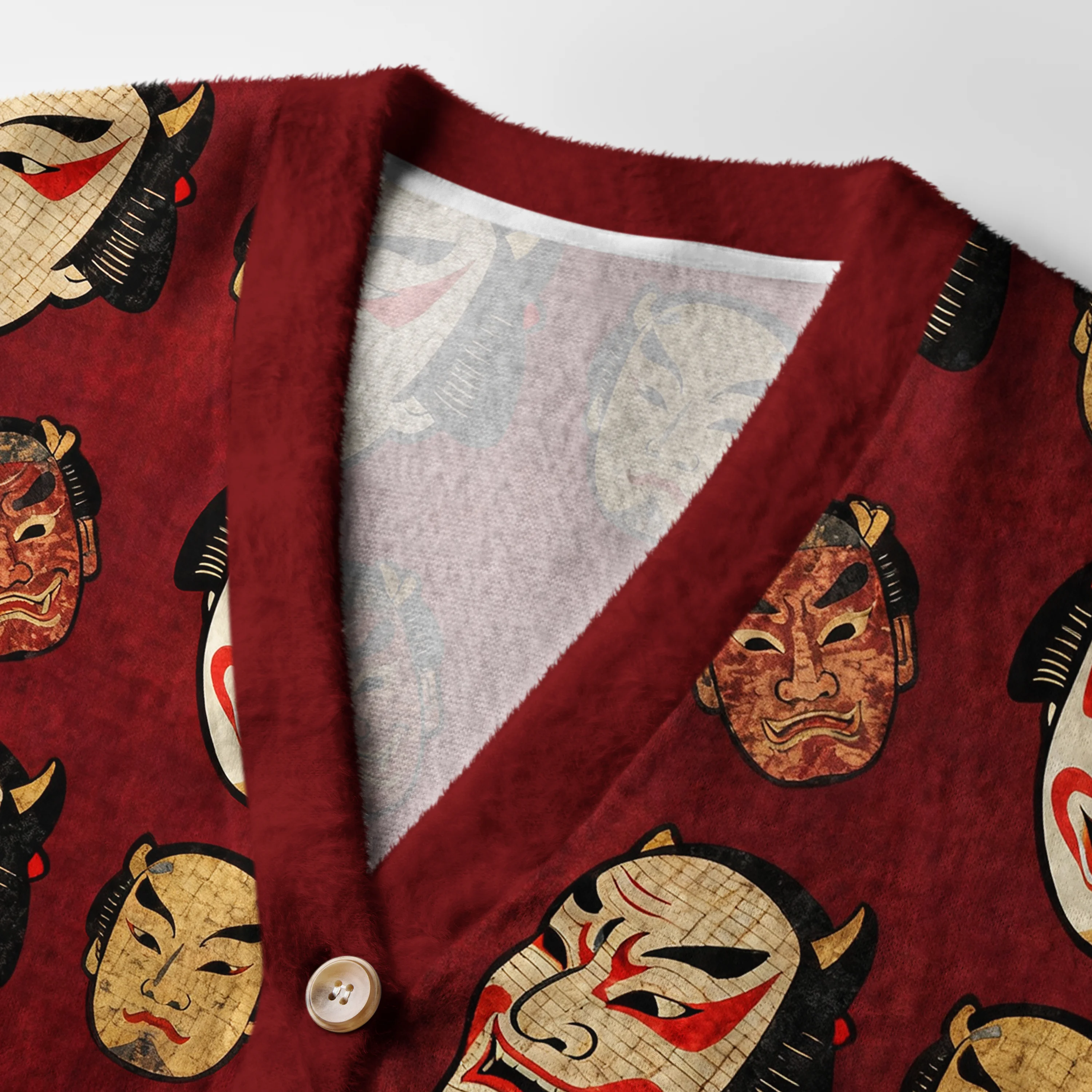 Japanese Mask Cardigan Sweater | Traditional Art Design Close-up detail of the Japanese mask cardigan sweater highlighting the unique mask designs and textured fabric.