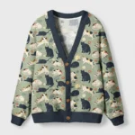 Front view of the playing cats cardigan sweater featuring cute cat designs on a green background.